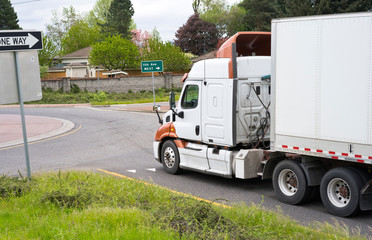 Big rig semi truck with semi trailer going on circle intersection of the street