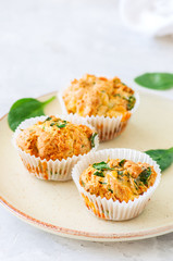 Savory potato spinach and feta muffins served on a plate. White stone background.