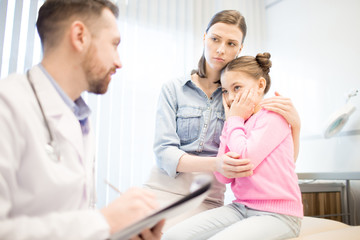 Fototapeta premium Anxious woman and her daughter listening to doctor opinion about diagnosis during appointment