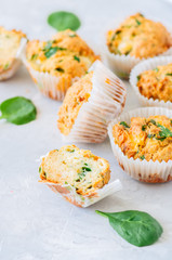 Savory potato spinach and feta muffins served on a plate. White stone background.
