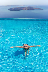 Woman enjoying relaxation in pool and looking at the view