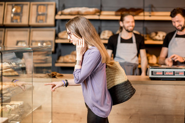 Woman choosing pastry in the shop