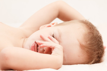 Obraz na płótnie Canvas cute caucasian little boy sleeping on white background