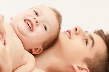Cute boy and little brother relax in a white bedroom. Family with children at home. Love, trust and tenderness