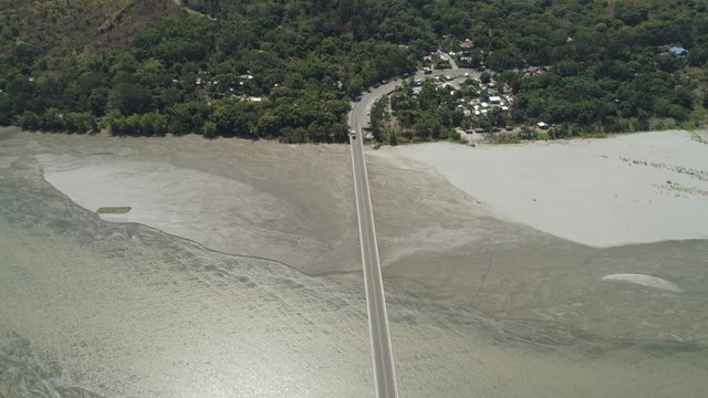 Modern bridge over river with cars in a mountain province Philippines,Luzon. Aerial view Bucao Bridge.