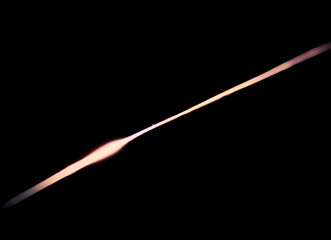 Narrow beam of light on the blade of a steel knife on a black abstract background