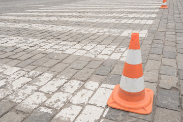 Old orange traffic cones at road.