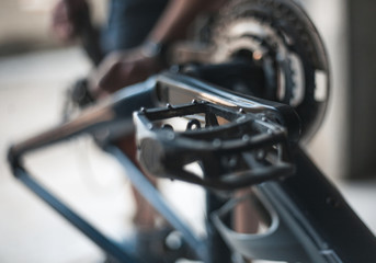A guy athlete serves and repairs his mountain bike in the garage