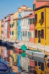 Fototapeta na wymiar Colorful houses, water canal and boats in Burano, Venice