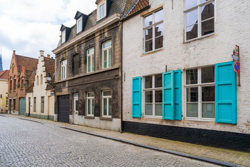 Old historical buildings along cobbled street in Bruges, Belgium