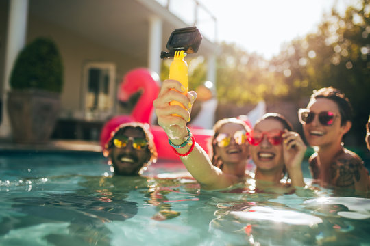 Woman with friends making selfie at pool party