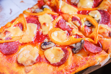 Cutting pepperoni pizza on slices with knife.