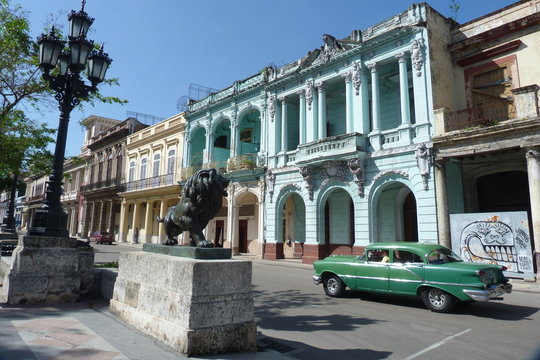 Prado mit Löwenskulptur und Oldtimer in Havanna.