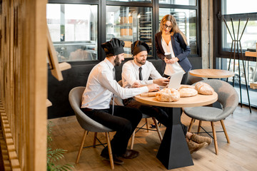 Bakers with businesswoman in the cafe