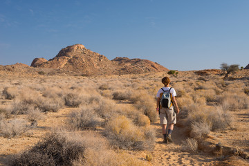 Obraz premium One person hiking in the Namib desert, Namib Naukluft National Park, Namibia. Adventure and exploration in Africa. Clear blue sky.