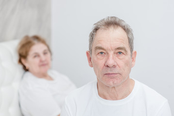 conflict of an elderly couple on the bed in the bedroom