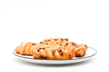Closeup of mini danish pastries with pecan nuts on top in the plate on white background.