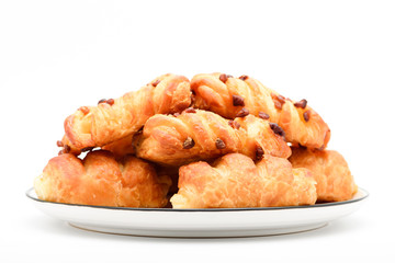 Closeup of mini danish pastries with pecan nuts on top in the plate on white background.