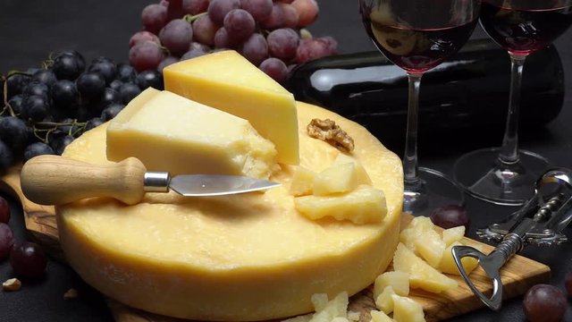 Video Whole round Head of parmesan or parmigiano hard cheese, grapes and wine