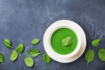 Fresh creamy spinach soup in bowl on table top view.