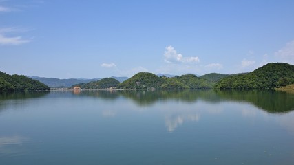 Fototapeta premium Quiet morning at Begnas lake, lake near Pokhara, Nepal. Hills on the shore covered by green forests.