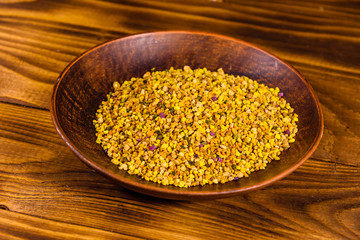 Ceramic plate with bee pollen on wooden table
