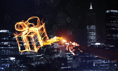 Concept of celebration with fire burning gift symbol on night city background