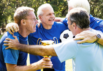 Team of mature football players winning the cup © Rawpixel.com