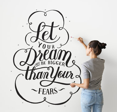 Female Artist Writing A Life Motivation Quote On The Wall