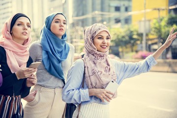 Islamic friends calling taxi on the street
