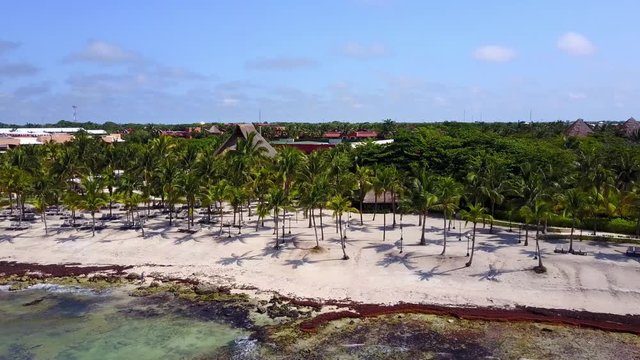 Aerial drone shot. Aerial view from above, birde eye view at an luxury resort hotel beach of a tropical coast. Turquoise water of the Caribbean Sea. Riviera Maya Mexico.