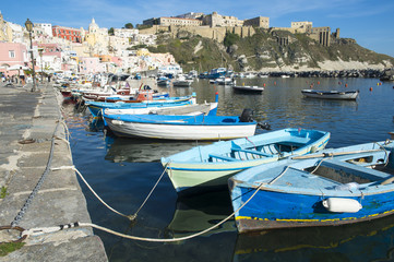 Obraz premium Beautiful view of traditional fishing boats moored in Corricella harbour on the island of Procida, Italy.