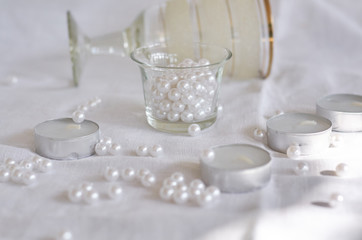 Fototapeta na wymiar candle, white beads and glass bowl