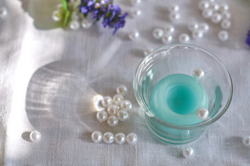 candle, lilac flower, white beads and shade from glass bowl