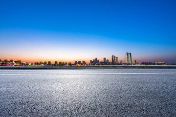 empty asphalt road with city skyline