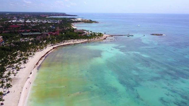 Aerial drone shot. Aerial view from above, birde eye view at an luxury resort hotel beach of a tropical coast. Turquoise water of the Caribbean Sea. Riviera Maya Mexico.