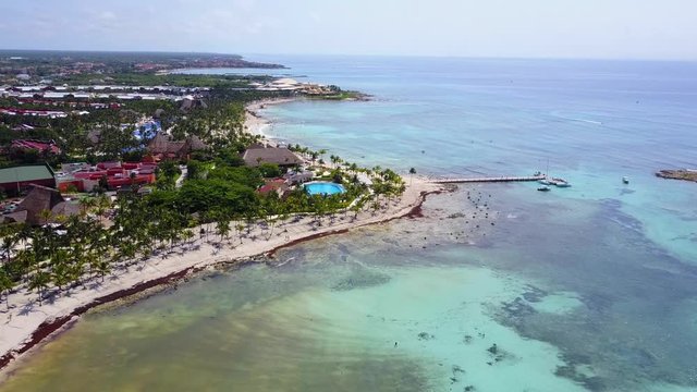 Aerial drone shot. Aerial view from above, birde eye view at an luxury resort hotel beach of a tropical coast. Turquoise water of the Caribbean Sea. Riviera Maya Mexico.