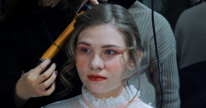 The hairdresser does a hairdress to beautiful model before photosession