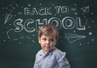 Adorable little boy with blackboard and back to school concept