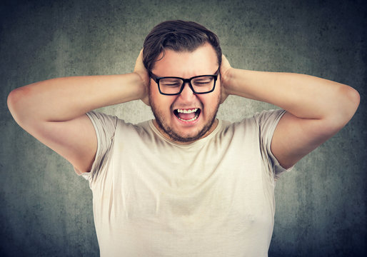 Stressed man having nervous breakdown screaming