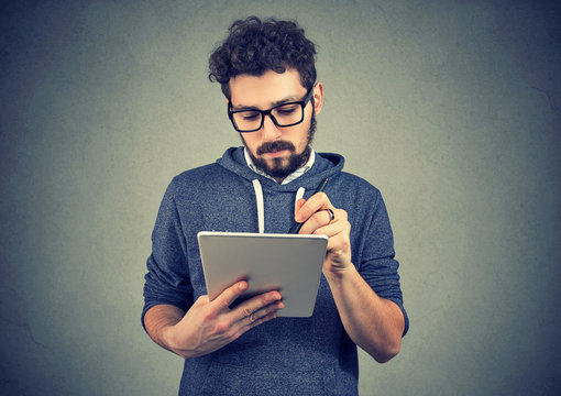 Serious hipster man using tablet computer