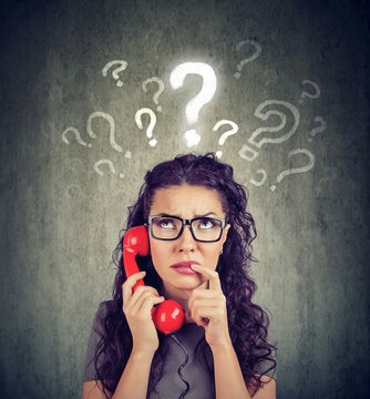 Upset worried confused woman talking on a phone has many questions