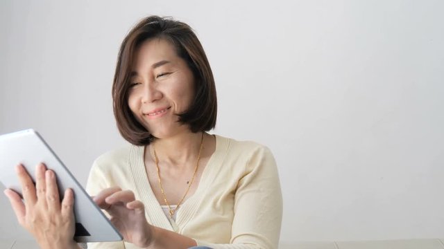 Asian woman using laptop on couch with natural light, lifestyle concept. 
