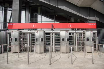 Fototapeta premium Entrance to office through big in full human growth stainless steel turnstiles.
