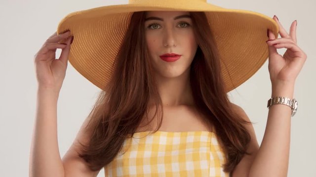 closeup portrait of woman with large straight hair wears big summer yelow hat. wOMAN IN HAT SUMMER VIBES, CLOSEUP PORTRAIT. sLOWMOTION BLOWING HAIR