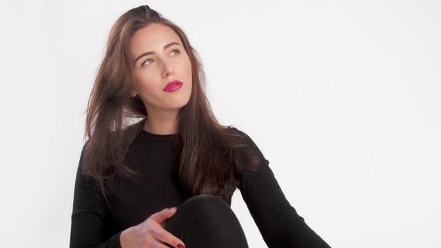 woman with long straight hair blowing in air in studio separate on white background. Ideal skin, slow motion 60fps, looking at camera