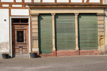 Facade of a old house with wooden closed shutters in the sun