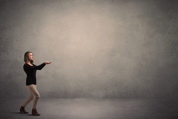 Caucasian woman standing in front of a blank grunge wall