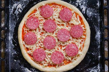 Fresh original Italian raw pizza, preparation on a baking tray in the oven