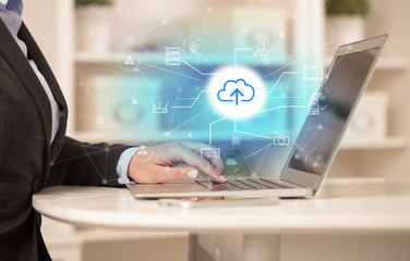 Business woman in homey environment using laptop with  online storage and cloud technology concept
